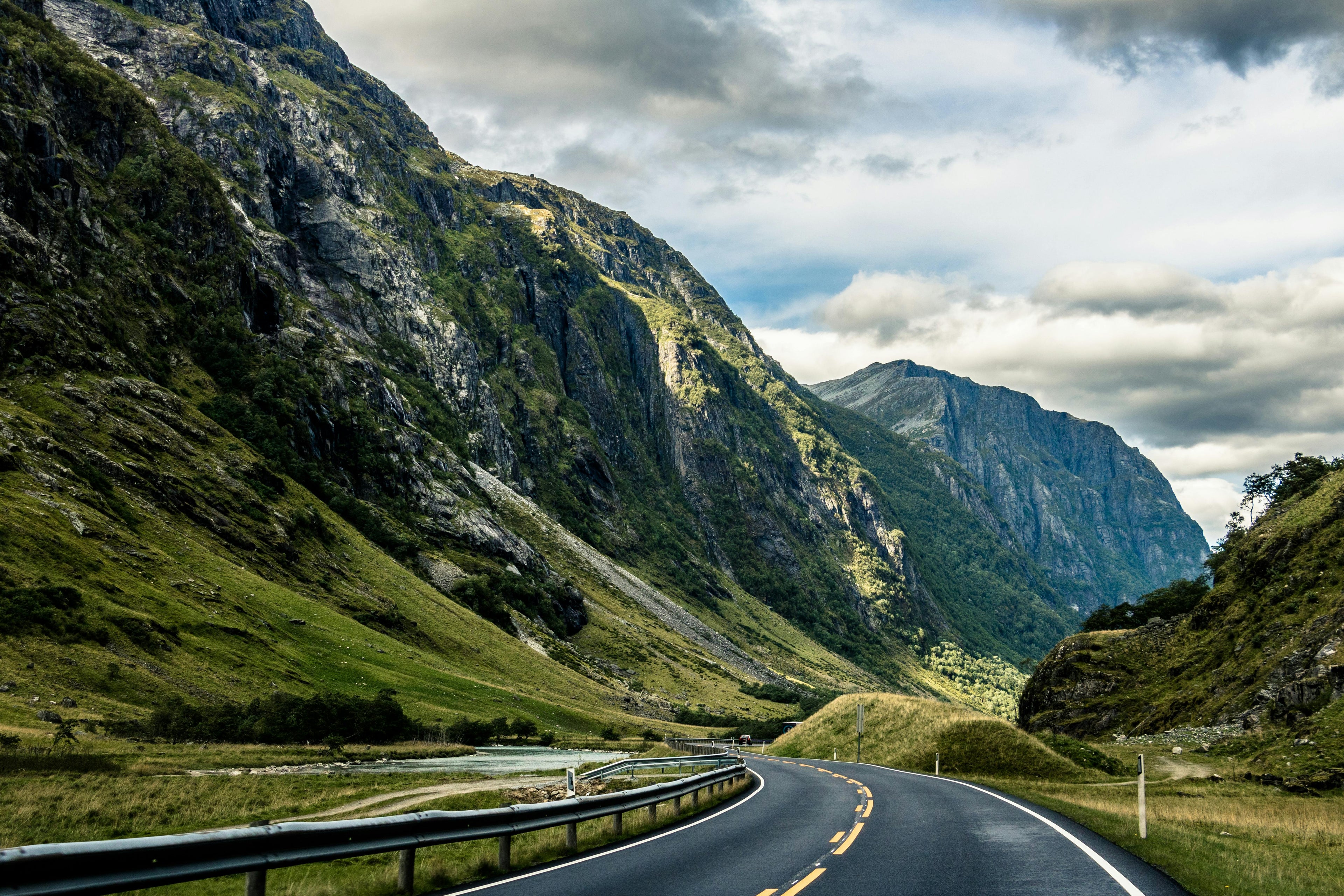 Mountainous landscape with a winding road and cloudy sky